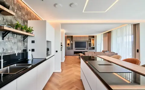 Moderne Küche mit Kochinsel und Wohnbereich. Die indirekte Beleuchtung unterstreicht die Eleganz. Informieren Sie sich über spanndecke kosten für Ihr Zuhause.