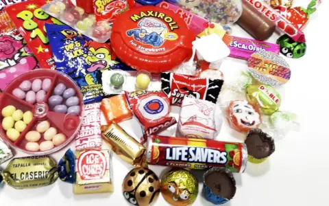 Un surtido de chuches años 60, con caramelos, chicles y chocolates, evocando la nostalgia de la infancia.