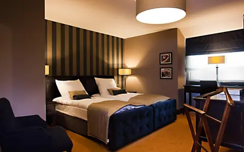 Przytulny pokój hotelowy z dużym łóżkiem, idealny na romantyczny wypad. Co można robić w Lublinie z dziewczyną? Tu na pewno odpoczniecie.