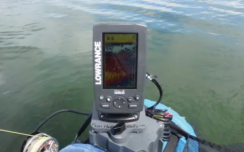 Branchement sondeur Lowrance sur un bateau, affichant une carte de pêche. La sonde est connectée, prête pour la pêche.