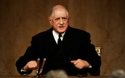 Charles de Gaulle, en costume sombre, s'exprime avec passion. Sa stature imposante et son regard déterminé marquent l'histoire.