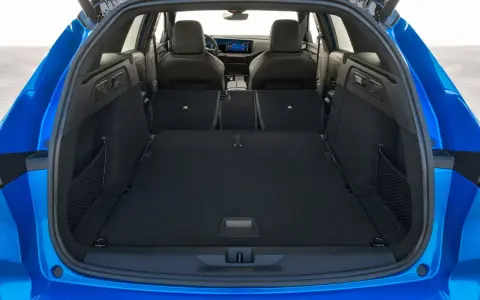Maletero Opel Astra azul, listo para cargar equipaje o compras. Amplio espacio interior con asientos abatibles.