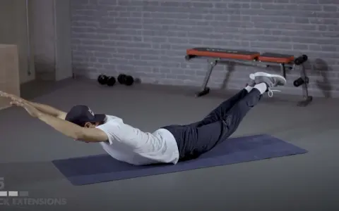 Mann macht Stabi-Training: Rückenstreckung auf Matte, Arme und Beine gestreckt.