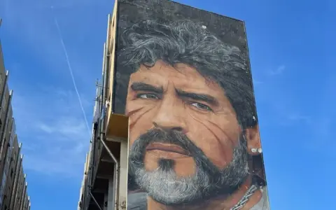 Un imponente murales di Maradona domina un palazzo a Napoli, un omaggio al Pibe de Oro.