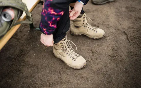 Vorbereitung für das Schneeschuhwandern: Schnüren der robusten Schuhe.