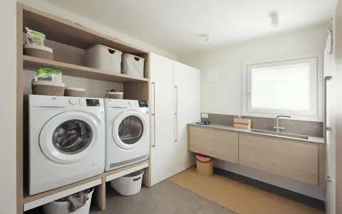 Progetto bagno con lavanderia: lavatrice, asciugatrice, lavabo e armadi. Soluzione funzionale e moderna.