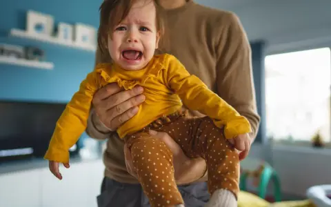 Ein weinendes Kind (2 Jahre) wird von seinem Vater gehalten. Es sagt "Mama weg!" und ist untröstlich.
