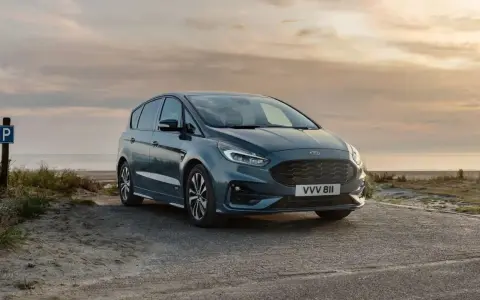 Ford S-Max gris aparcado en la playa al atardecer. Las medidas del Ford S-Max son ideales para escapadas familiares.