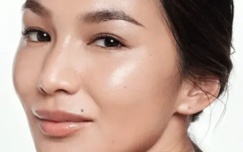 Rostro de mujer con piel radiante. Aprende cómo usar ácido glicólico para una piel luminosa y renovada.