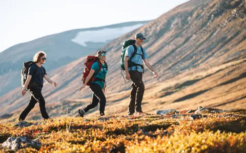 Vandrare njuter av solnedgången på väg mellan Kvikkjokk och Saltoluokta.
