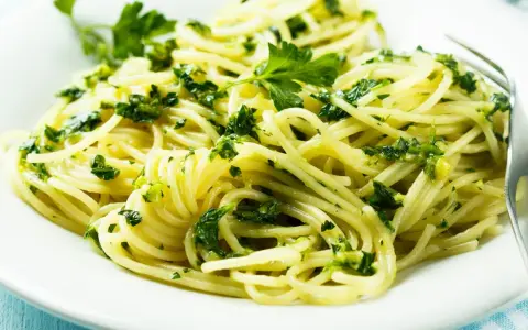 Pyszne spaghetti z zielonym pesto i świeżą natką pietruszki. Idealne na szybki obiad, inspiracja z przepisów z pesto.