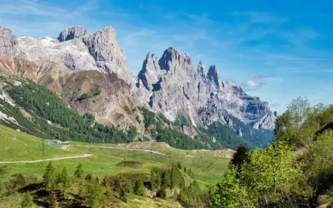Panorami mozzafiato al Passo Rolle, con imponenti vette rocciose che si stagliano contro il cielo azzurro. L'altitudine regala un'aria pura e una vista indimenticabile.