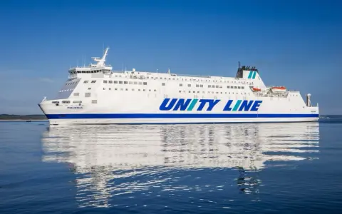 Biały prom Unity Line "Polonia" płynie po spokojnym, błękitnym morzu.