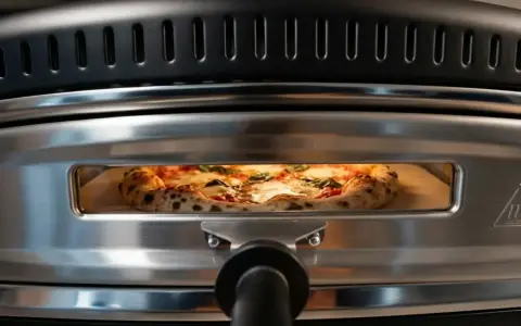 En perfekt vedugnsbakad pizza med bubblig kant och färska örter gräddas i en modern ugn.