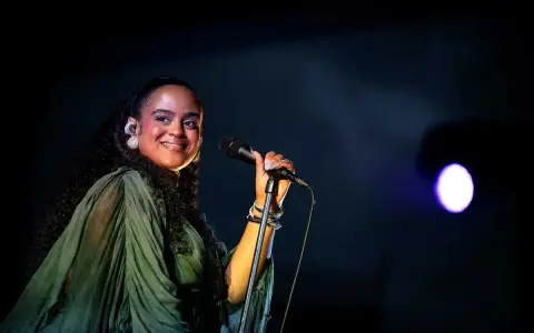 Seinabo Sey njuter av att uppträda på en konsert, med ett leende och mikrofonen i handen.