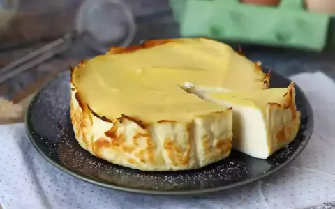 En krämig ricotta cheesecake, perfekt för ett enkelt ricotta recept. En bit är uppskuren och visar den lena insidan.