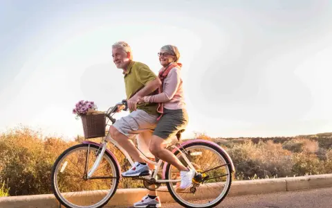 Pareja mayor disfruta de un paseo en bicicleta, celebrando la jubilación a los 61 años con la nueva reforma.