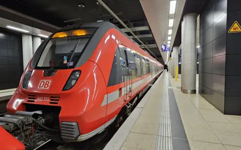 Röd DB-tåg på en station, redo att ta dig från berlin flygplats till centrum.