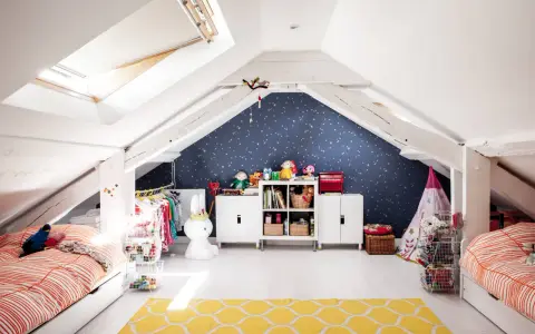 Kreative kinderzimmer dachboden ideen: zwei Betten, Spielzeug, Kleiderständer und ein Sternenhimmel an der Wand schaffen eine gemütliche Atmosphäre.