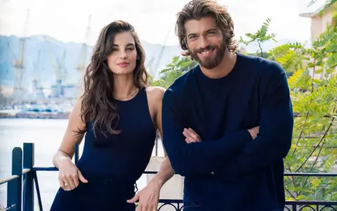 Coppia sorridente con sfondo di un porto, il suo sguardo è viola come il mare.