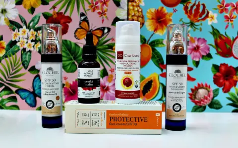 Kremy z filtrem SPF 30 i SPF 50, olejek z pestek malin i krem ochronny z dwutlenkiem tytanu na tle tropikalnych kwiatów i motyli.