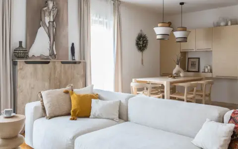 Jasny salon z sofą, stołem i krzesłami w stylu modern organic.
