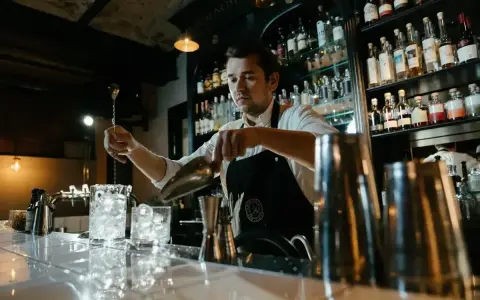 Barman w Anglii przygotowuje drinka. Zastanawiasz się, ile zarabia barman w Anglii?