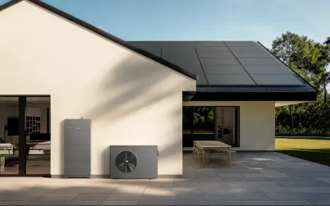 Modernes Haus mit Solaranlage auf dem Dach und Wärmepumpe. Ein Energiekonzept, das u wert optimiert und die Umwelt schont.
