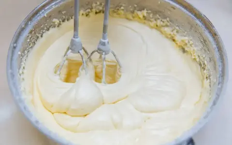 Mieszadła miksera ubijają kremowy, gładki krem z mascarpone. Dowiedz się, jak uratować zwarzony krem z mascarpone, by deser był idealny.