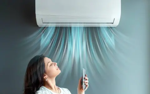 Donna rilassata sotto l'aria fresca di un climatizzatore inverter, che ne spiega il significato di comfort e risparmio energetico.