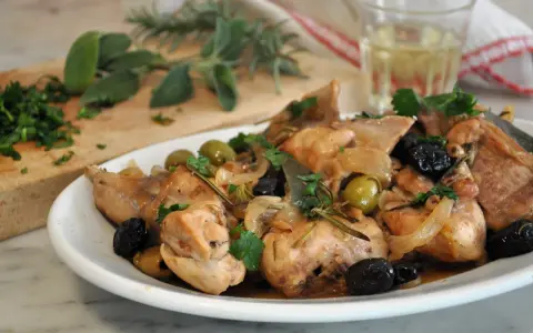 Piatto di coniglio alla cacciatora in bianco, con olive, cipolle e rosmarino. Un classico della cucina italiana.