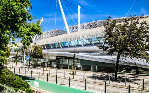Moderne Architektur auf dem Expo Gelände Lissabon mit einem langen, geschwungenen Dach und Glasfassaden.