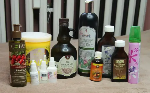 Kolekcja kosmetyków, w tym balsam do włosów i olejki, które pomogą w pielęgnacji kręconych włosów.