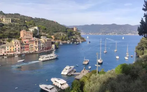 Colorati paesi della Riviera di Levante, con barche a vela e yacht che solcano il mare blu.