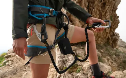 Wspinacz w uprzęży Salewa, gotowy na przygodę. Salewa co to za firma? To marka sprzętu outdoorowego, która zapewnia bezpieczeństwo w górach.