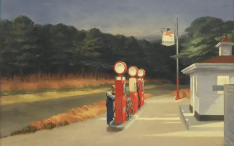 Une station-service isolée, typique des Edward Hopper paintings, avec un homme faisant le plein. L'atmosphère est calme, presque mélancolique.