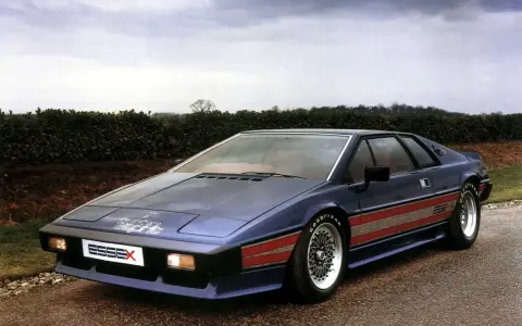Niebieski Lotus Esprit Turbo Essex z czerwonymi pasami na boku, zaparkowany na drodze.
