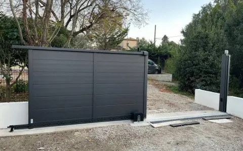 Emplacement moteur portail coulissant installé sur une nouvelle installation. Le portail est gris anthracite, moderne.