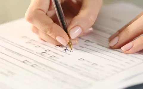 Dłoń zaznacza "TAK" na formularzu, co może być krokiem w procesie, jak uzyskać stopień niepełnosprawności.