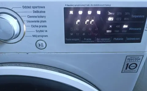 Pralka LG z wyświetlaczem pokazującym symbole programów: "Odzież sportowa", "Delikatne", "Ciemne kolory", "Usuwanie plam", "Ciche pranie", "Szybki 14", "Mój program". Widoczne też symbole temperatury i wirowania.