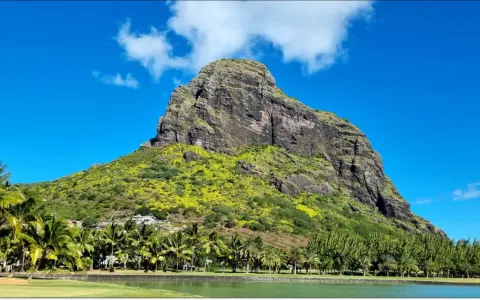 Mauritius pogoda marzec: majestatyczna góra porośnięta zielenią, palmy, jezioro i błękitne niebo.