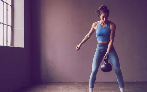 Frau trainiert mit Kettlebell, bereit für die 75 Hard Challenge.