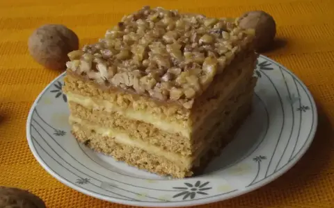 Pyszne ciasto miodowe z orzechami, jedno z 10 najlepszych ciast, na talerzyku z orzechami w tle.