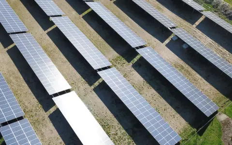 En stor solcellspark tar form. Solpaneler i rader fångar solens energi för att starta en grön framtid.