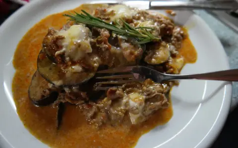 Herzhafte Auberginen-Hackfleisch-Auflauf, inspiriert von Omnia Rezepte, mit geschmolzenem Käse und Rosmarin garniert.