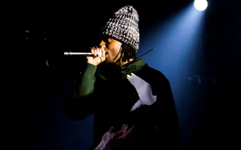 Playboi Carti Polska na scenie, w czapce i bluzie z gołębiem.