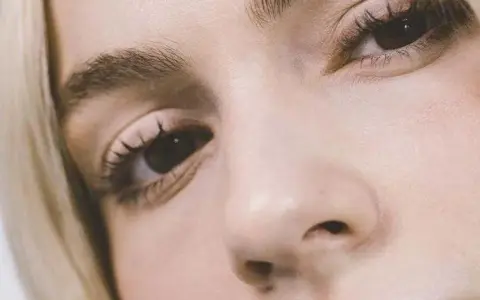 Primer plano de un ojo y nariz de mujer rubia. Consejos sobre como disimular las bolsas de los ojos.