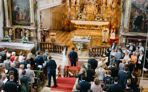 Hochzeit in der Kirche. Ein Paar heiratet, obwohl die Firmung nicht stattgefunden hat. Gäste verfolgen die Zeremonie.