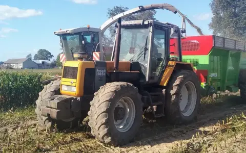Żółty ciągnik Renault 120.54 z przyczepą podczas żniw kukurydzy. Pytanie o jaki olej do silnika MWM Renault jest tu na miejscu.