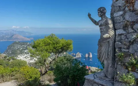 Statua antica domina il panorama mozzafiato di Capri. Un invito a scoprire cosa visitare a Capri, tra mare blu e Faraglioni.